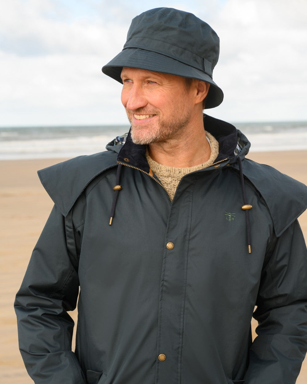 Navy coloured Lighthouse Long Waterproof Coat on beach background