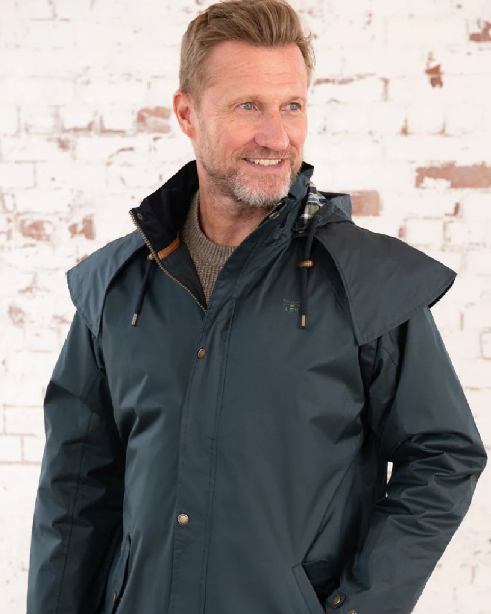 Navy coloured Lighthouse Stockman Long Waterproof Coat on wall background
