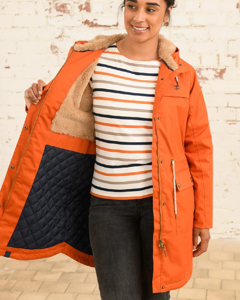Burnt Orange coloured Lighthouse Isobel Ladies Coat on wall background