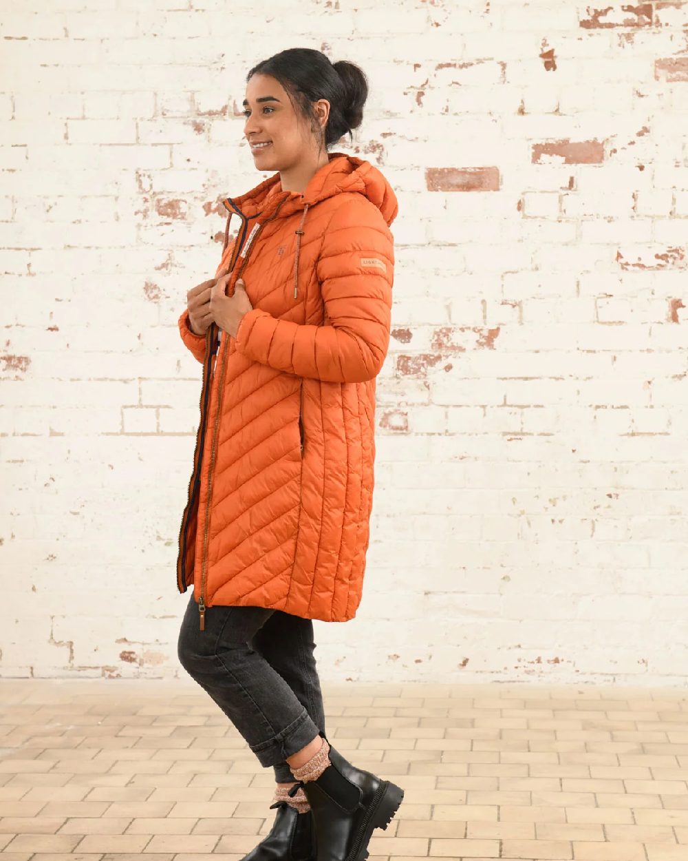 Burnt Orange coloured Lighthouse Laurel Ladies Coat on wall background