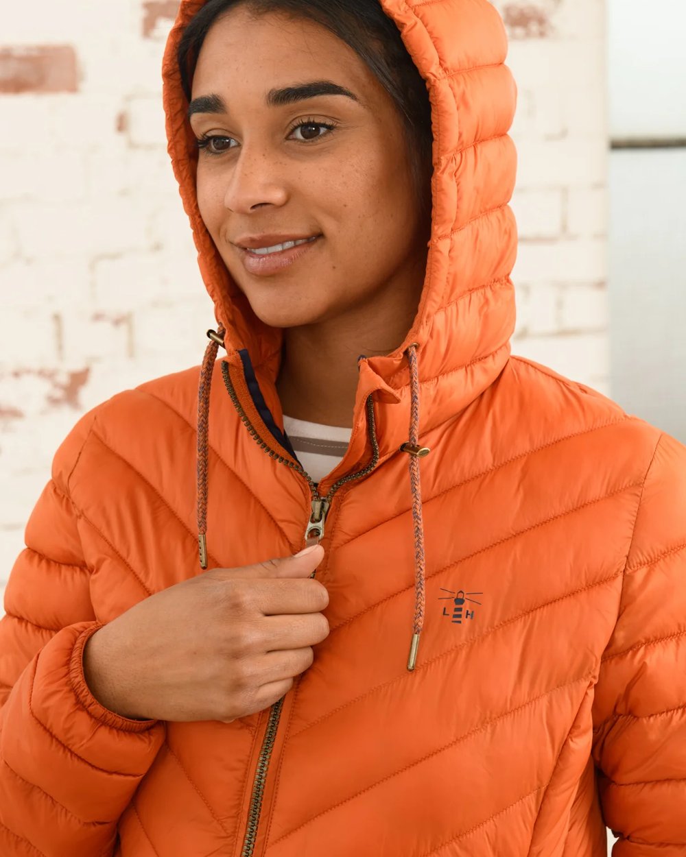 Burnt Orange coloured Lighthouse Laurel Ladies Coat on wall background