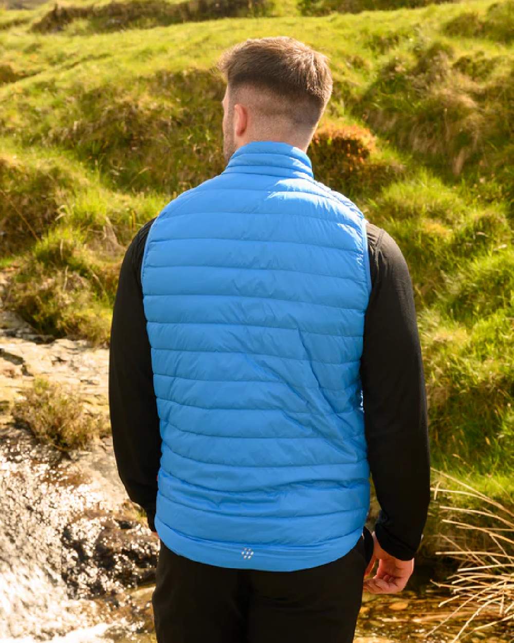 Royal coloured Mac In A Sac Mens Alpine Down Gilet on blurry green background