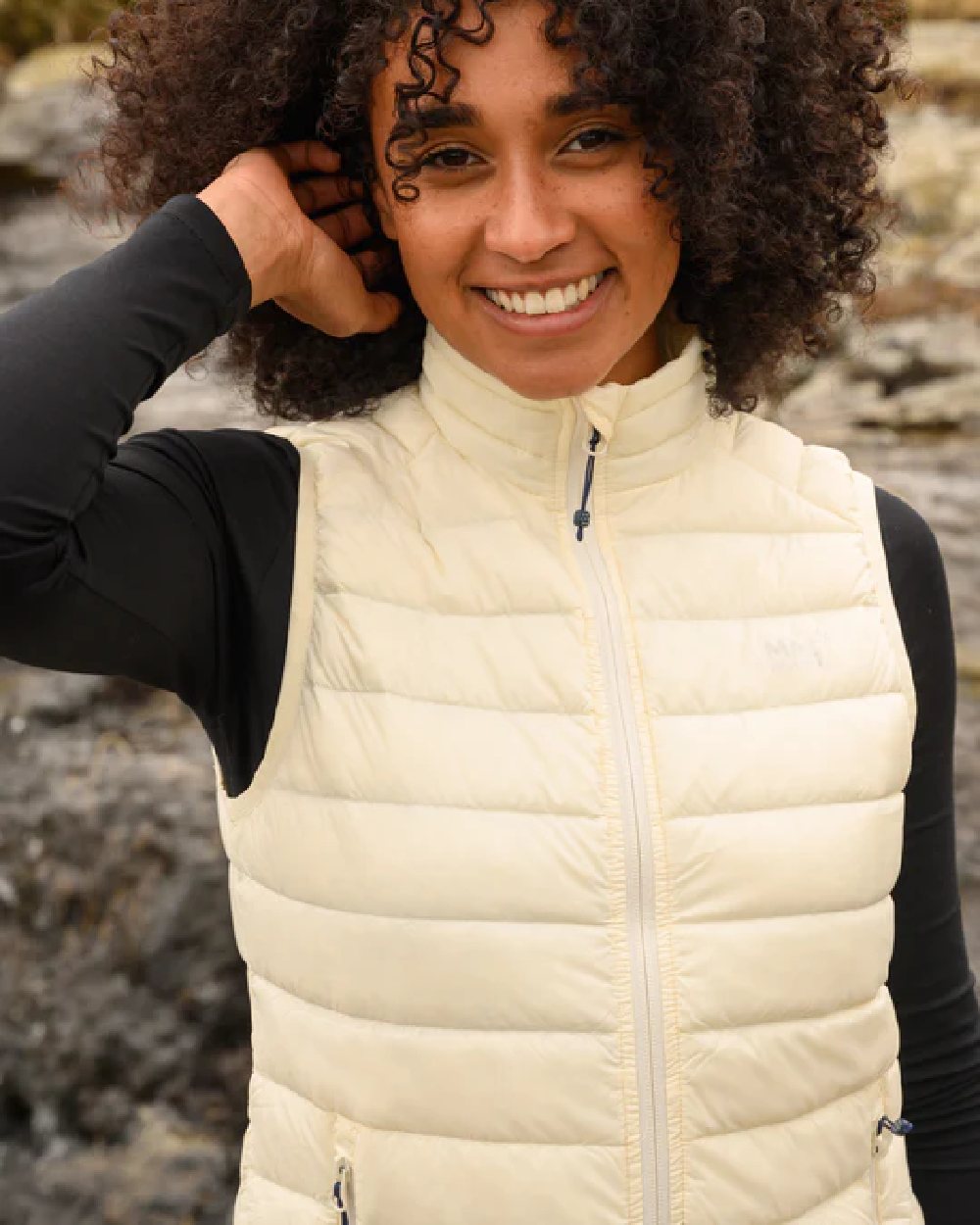 Ivory coloured Mac In A Sac Alpine Womens Down Gilet on blurry background