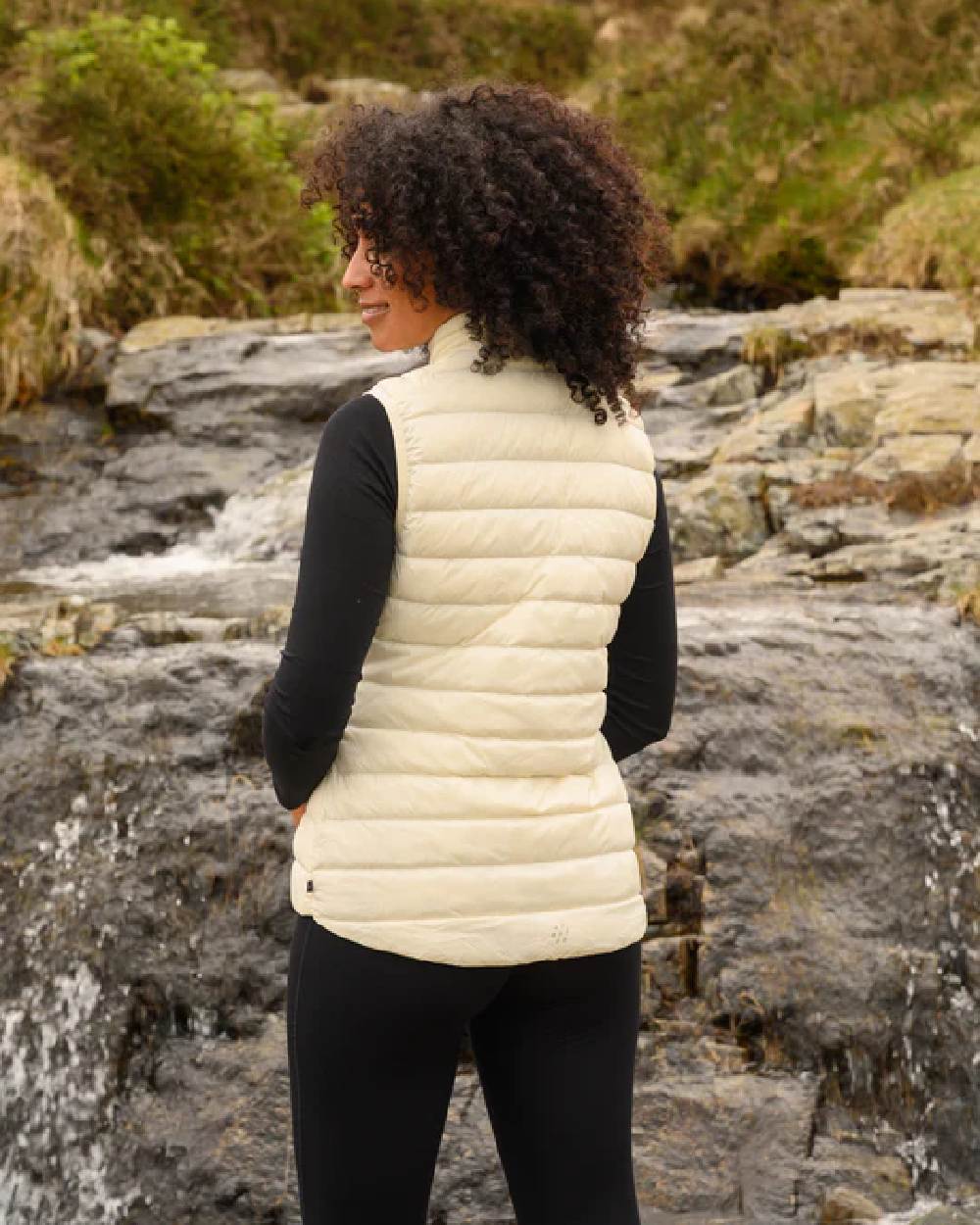 Ivory coloured Mac In A Sac Alpine Womens Down Gilet on blurry background