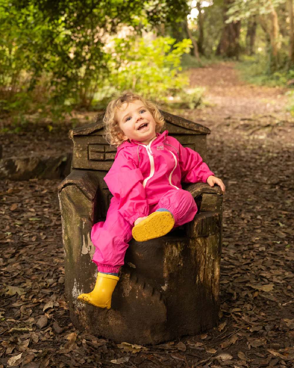 Pink coloured Mac In A Sac Origin 2 Puddlesuit on blurry background