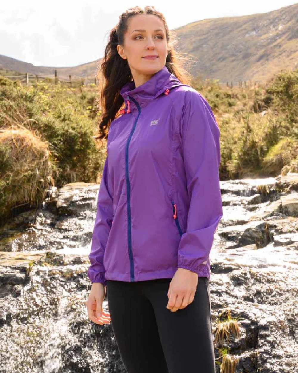 Purple coloured Mac In A Sac Packable Origin Waterproof Jacket on outdoor background