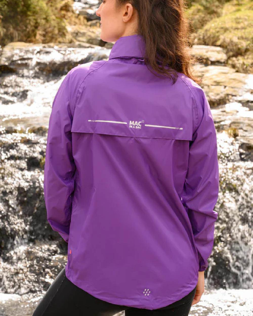 Purple coloured Mac In A Sac Packable Origin Waterproof Jacket on outdoor background