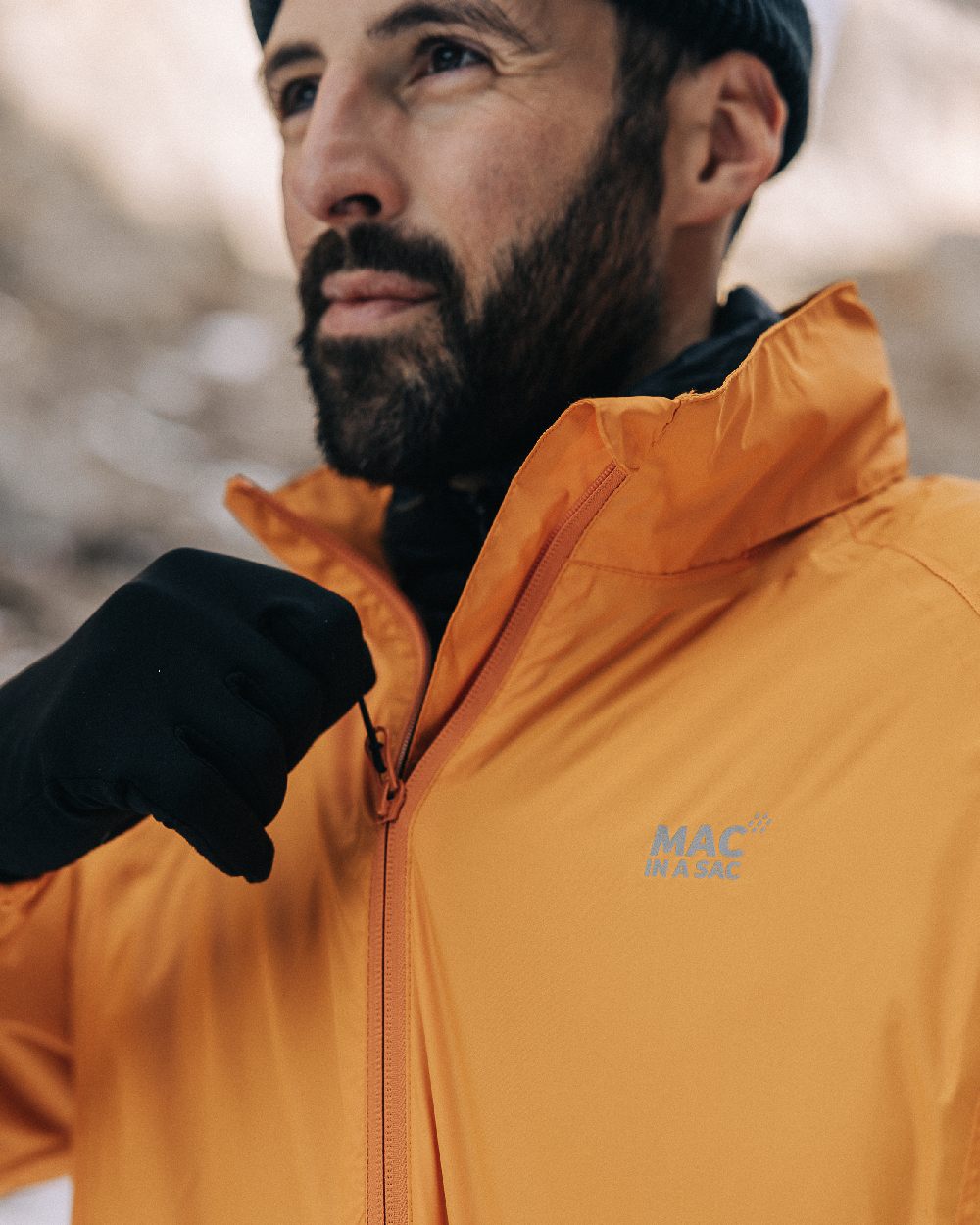 Soft Orange Coloured Mac In A Sac Origin Packable Waterproof Jacket on outdoor background