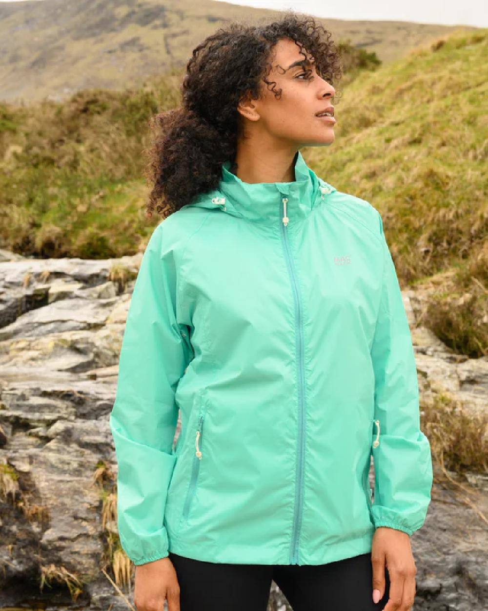 Tiffany Green coloured Mac In A Sac Packable Origin Waterproof Jacket on outdoor background