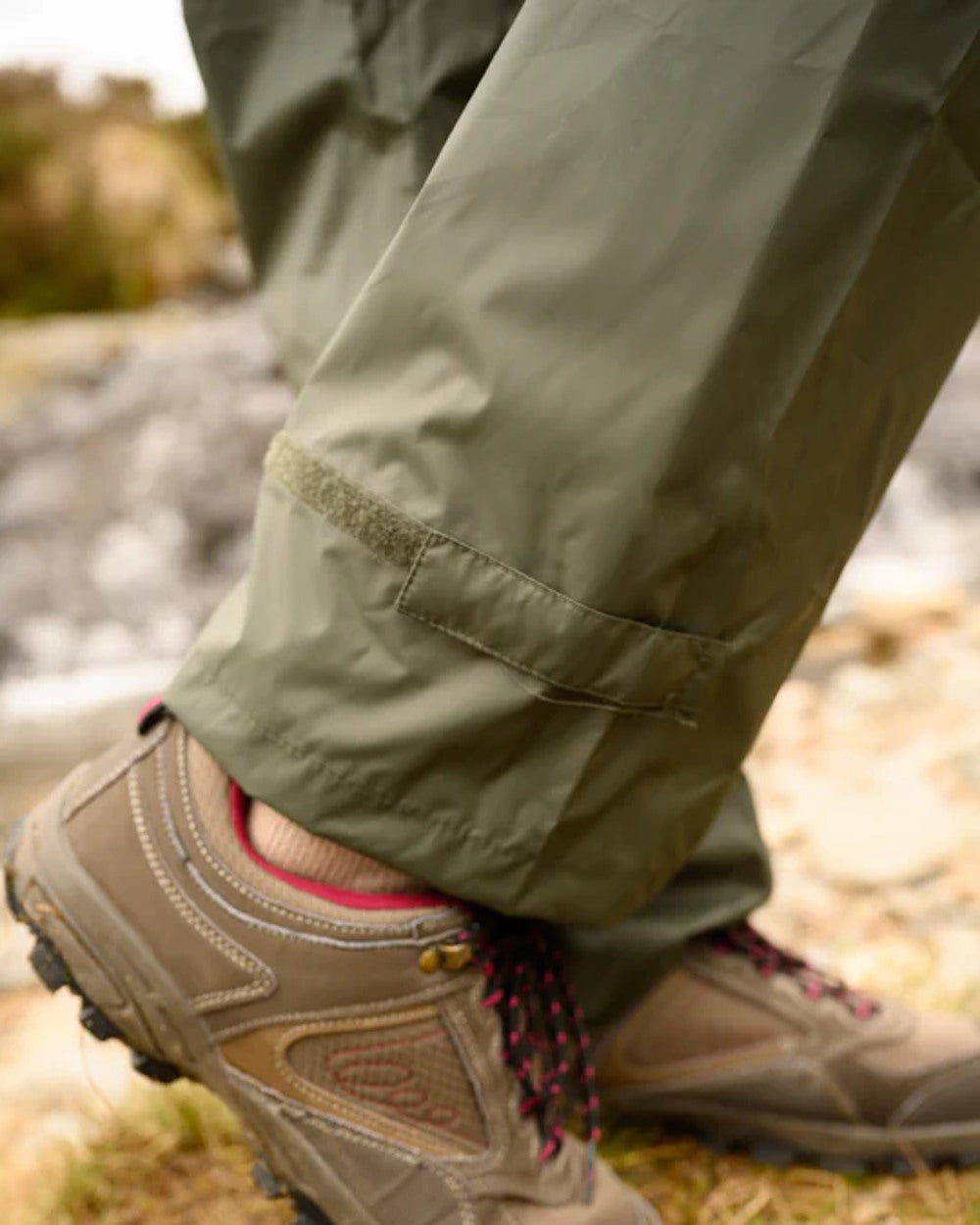 khaki coloured Mac In A Sac Origin Packable Waterproof Overtrousers on blurry background