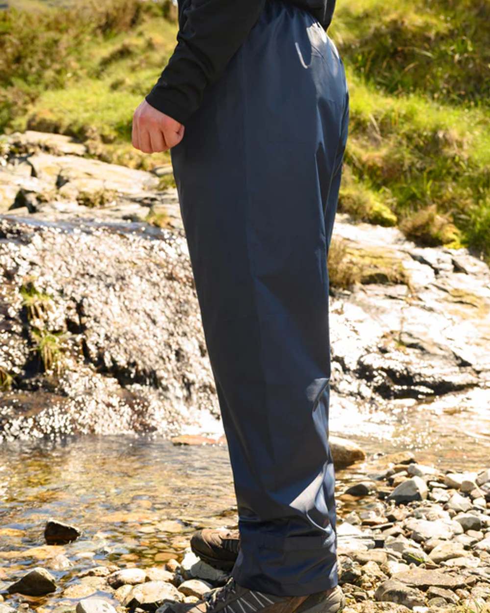 Navy coloured Mac In A Sac Origin Packable Waterproof Overtrousers on blurry background
