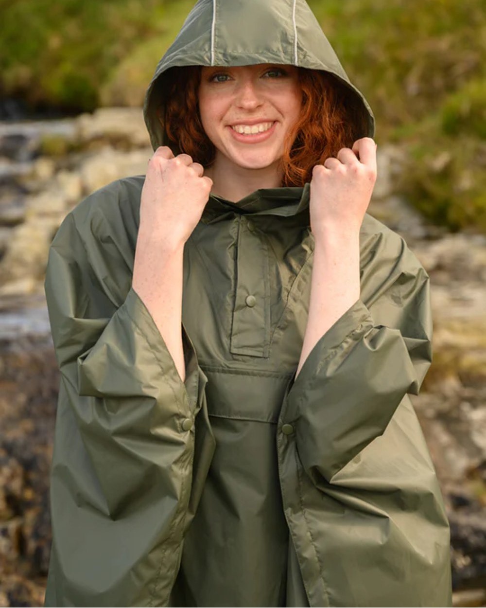 Khaki Coloured Mac In A Sac Origin Waterproof Poncho on blurry background