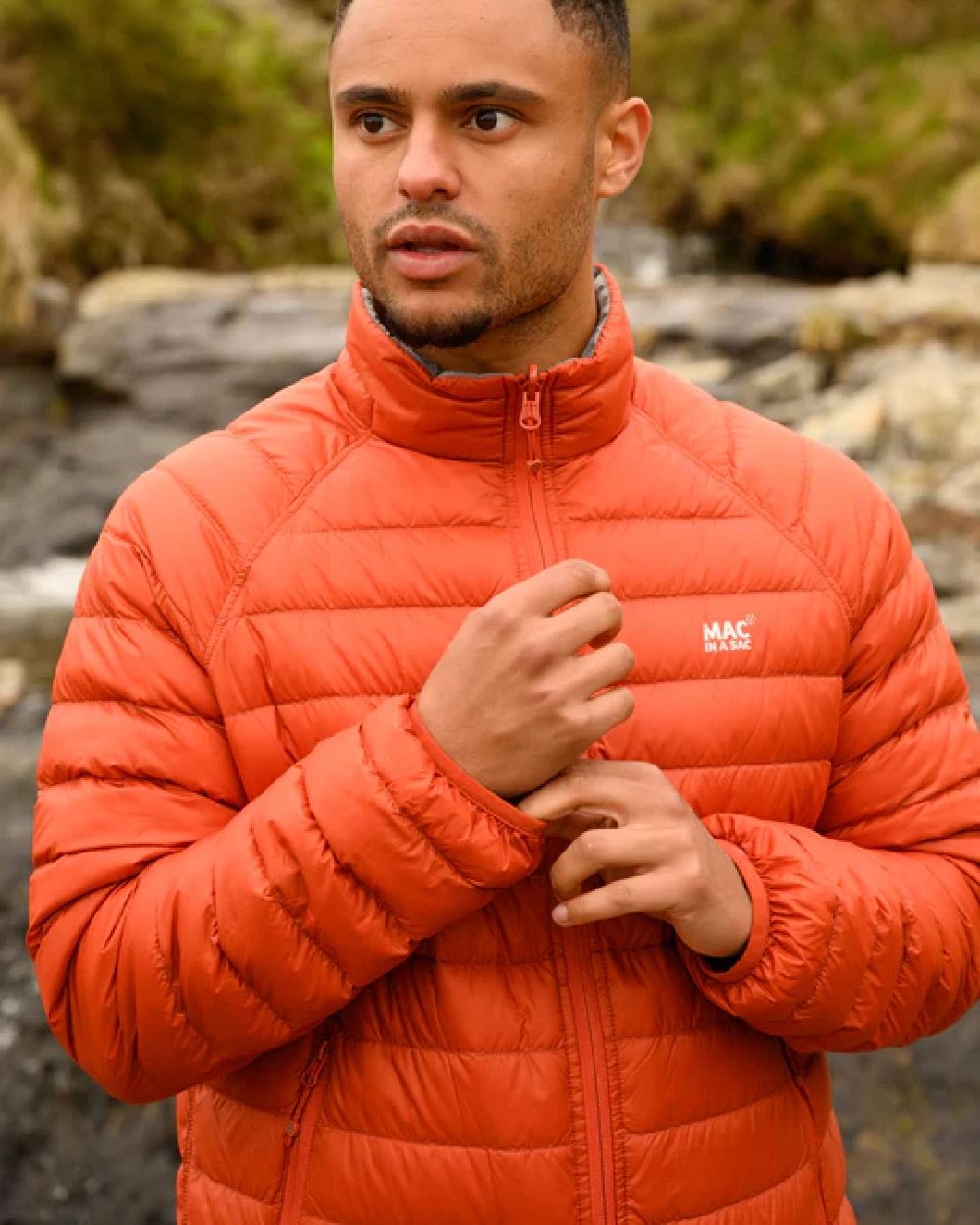 Burnt Orange Grey coloured Mac In A Sac Packable Mens Polar Down Jacket on blurry background