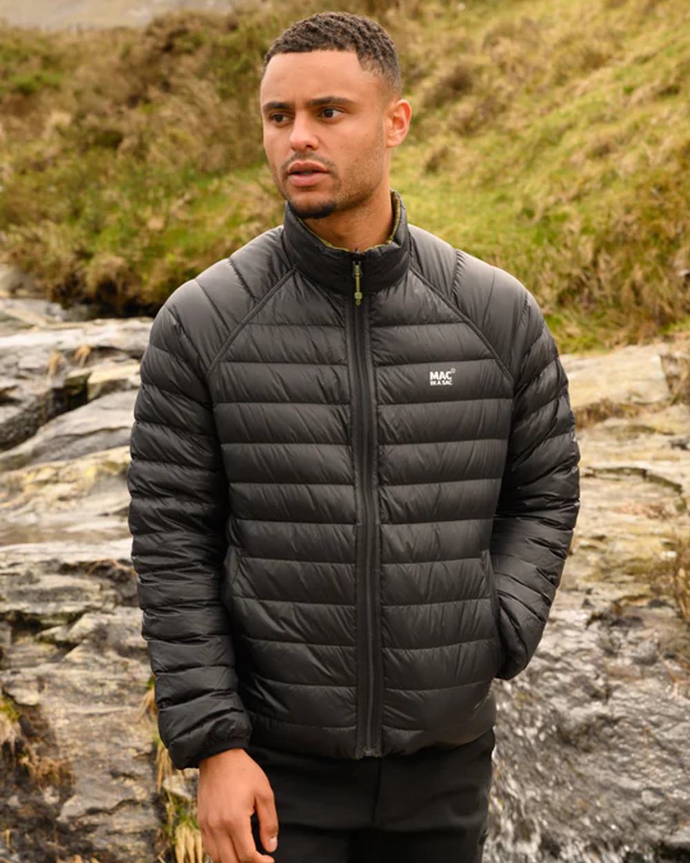 Khaki Black coloured Mac In A Sac Packable Mens Polar Down Jacket on blurry green background