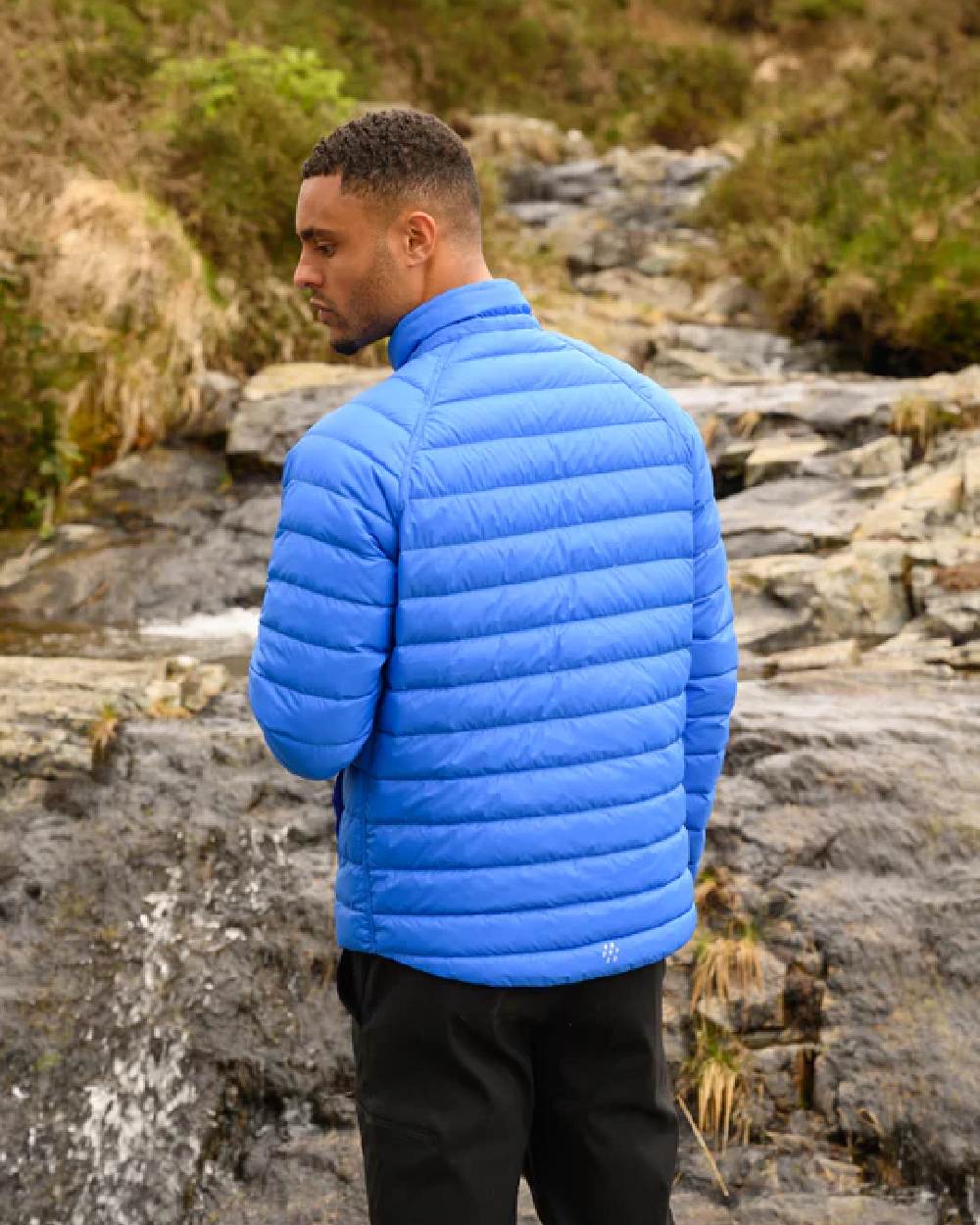 Navy Saxe Blue coloured Mac In A Sac Packable Mens Polar Down Jacket on blurry green background