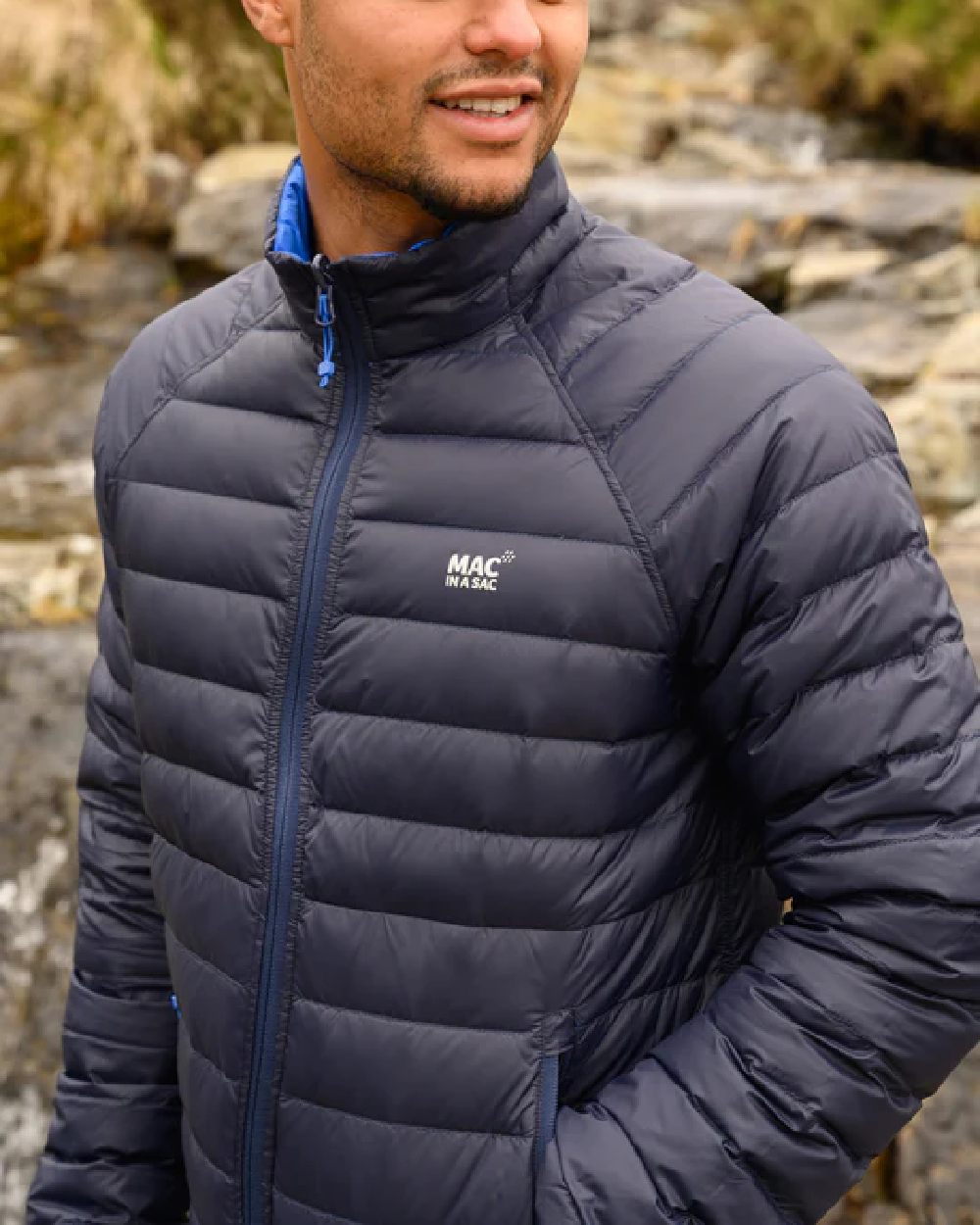 Navy Saxe Blue coloured Mac In A Sac Packable Mens Polar Down Jacket on blurry green background