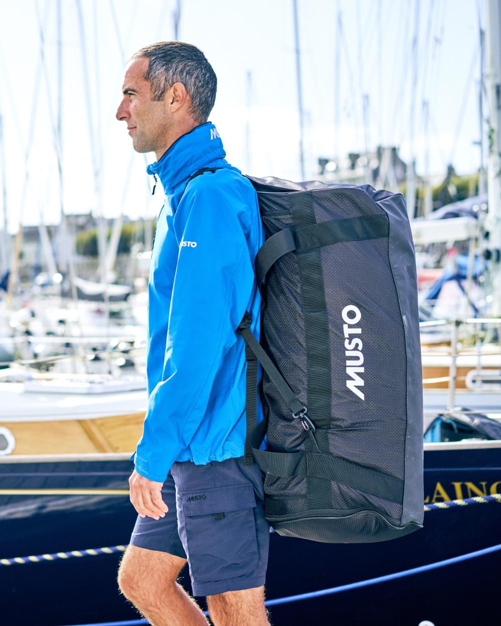 Black coloured Musto Essential 90L Duffel Bag on port background