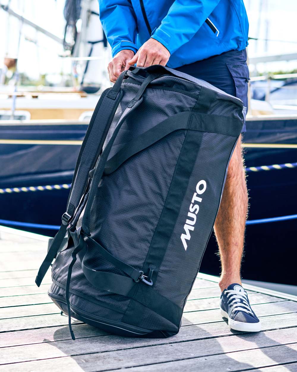 Black coloured Musto Essential 90L Duffel Bag on port background