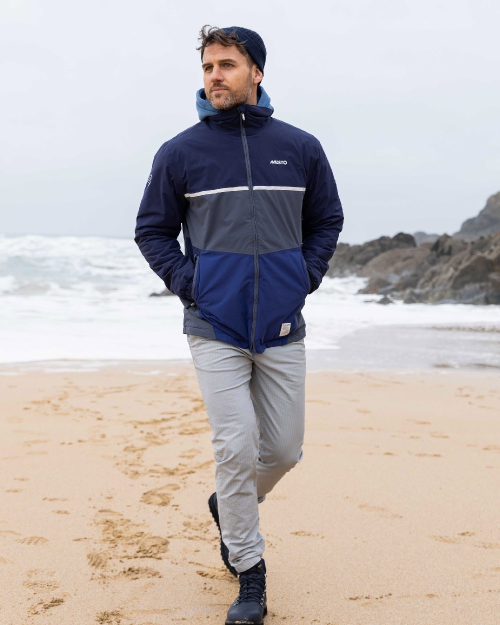 Ombre Blue Navy Coloured Musto Mens 64 Regatta Jacket on beach background