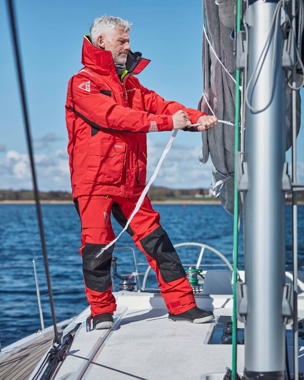 True Red Musto Mens Br2 Offshore Trouser 2.0 on blurry background