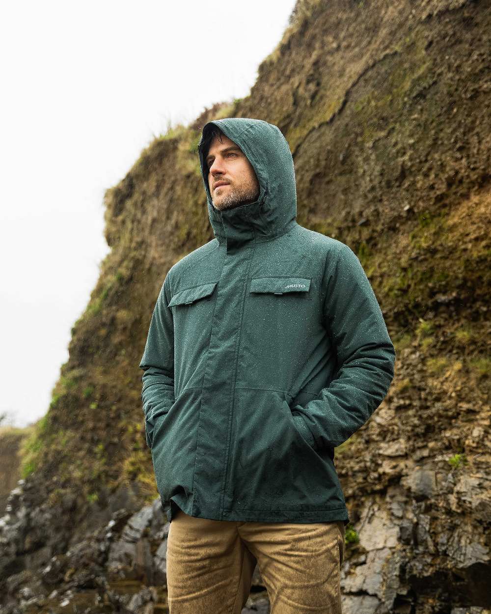 Darkest Spruce Coloured Musto Mens Insulated Rain Jacket on mountain background