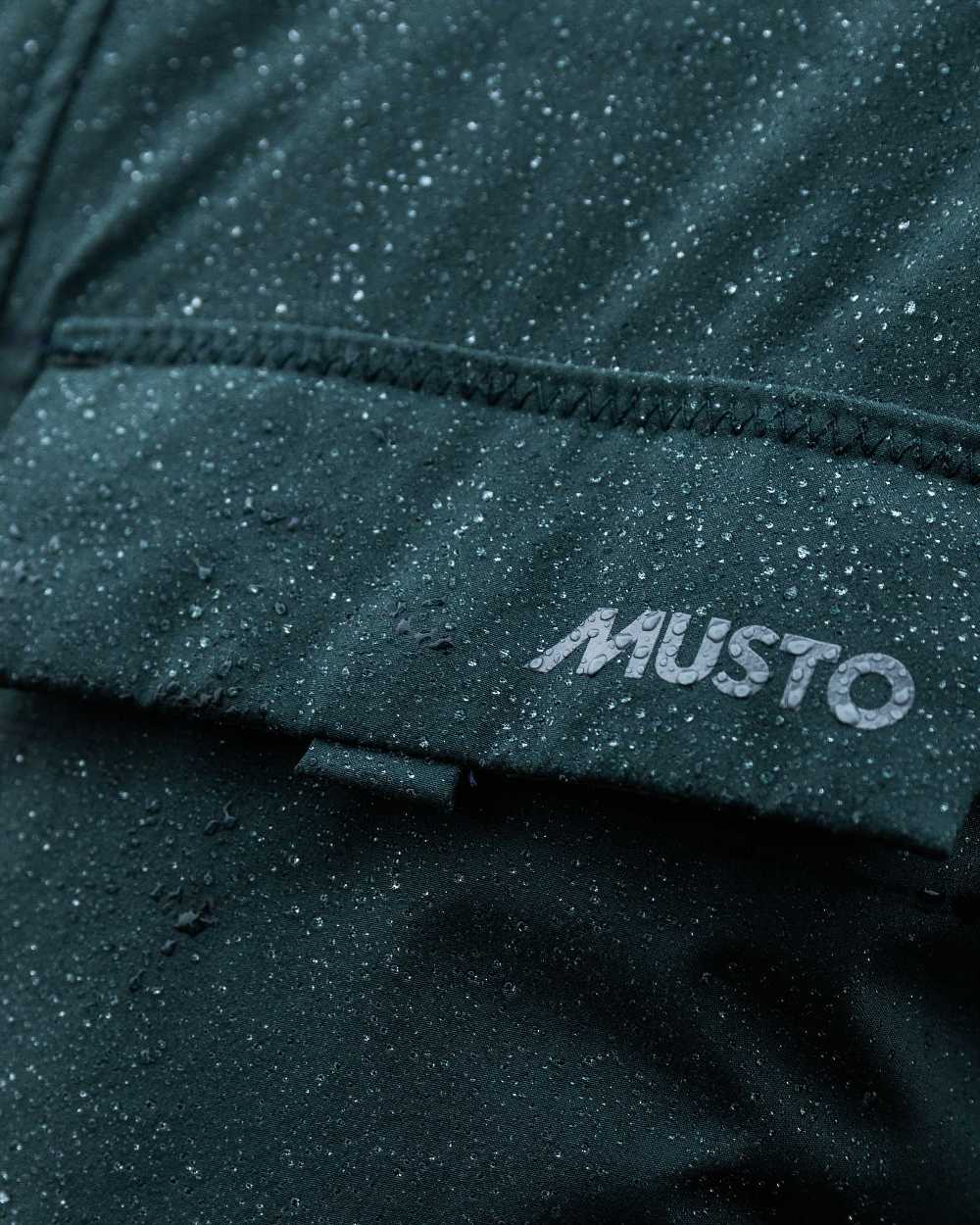 Darkest Spruce Coloured Musto Mens Insulated Rain Jacket on blurry background