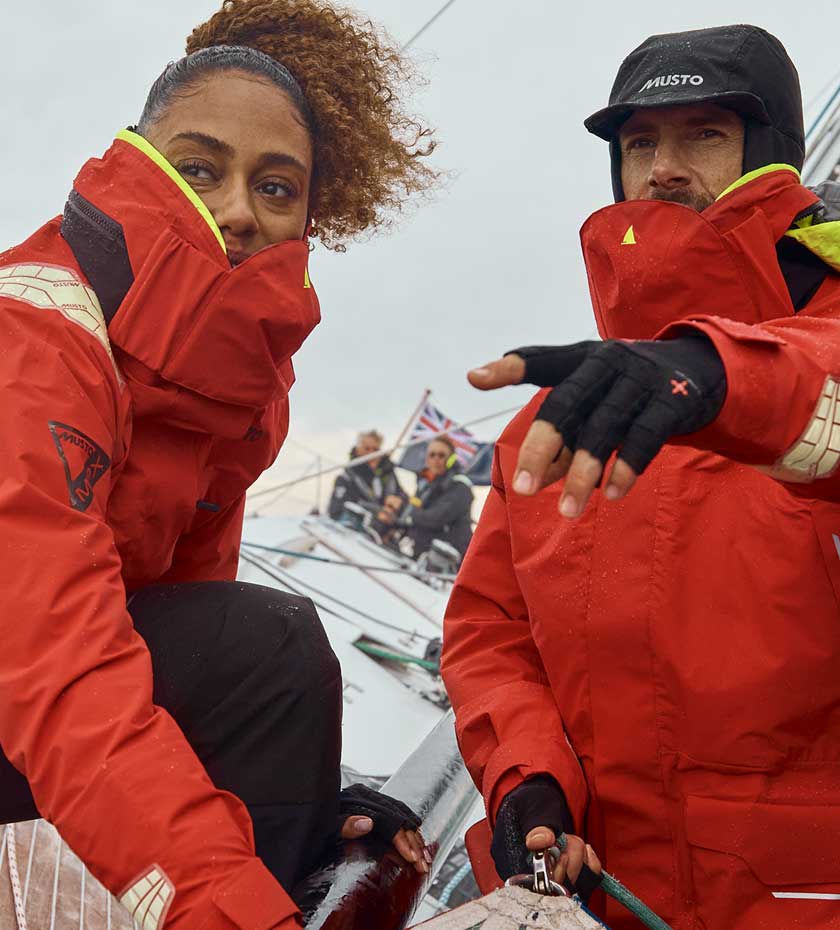 Musto Sailing Jackets, a man and woman in red offshore sailing jackets on a racing yacht.