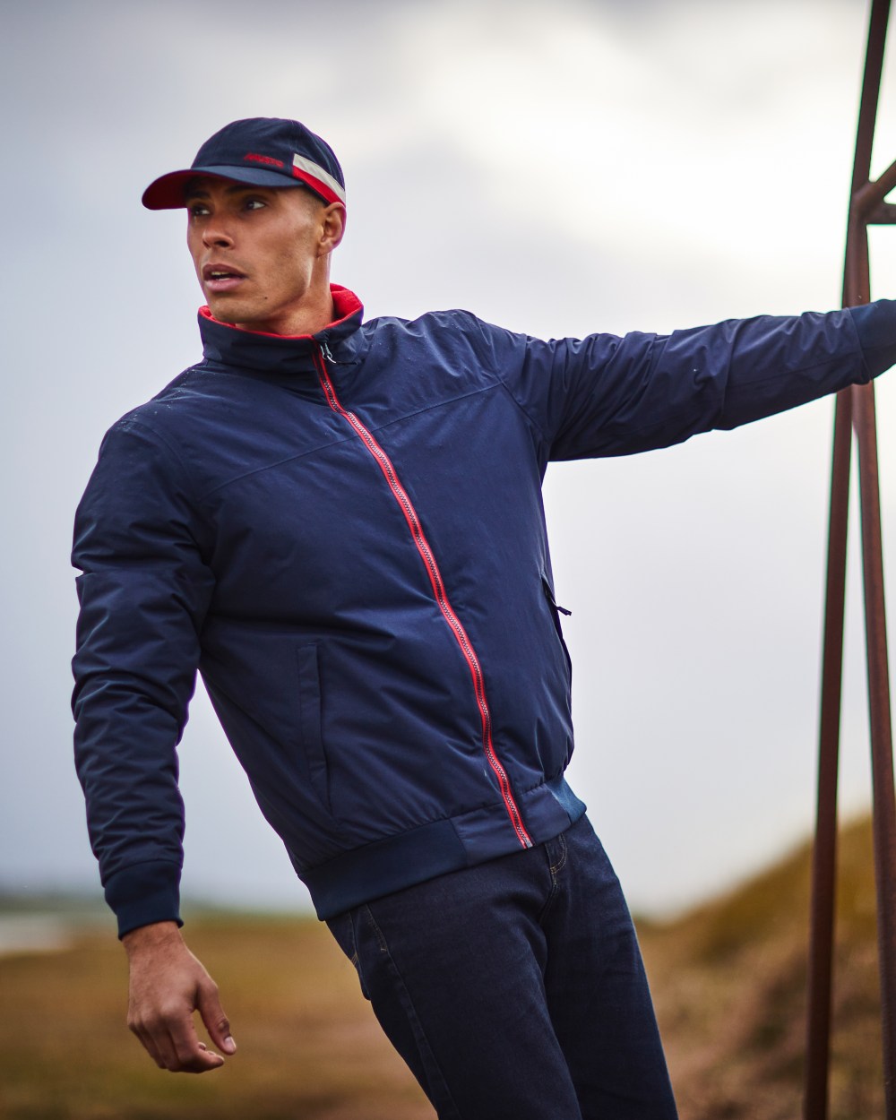 Navy Red coloured Musto Snug Blouson Jacket 2.0 on blurry background