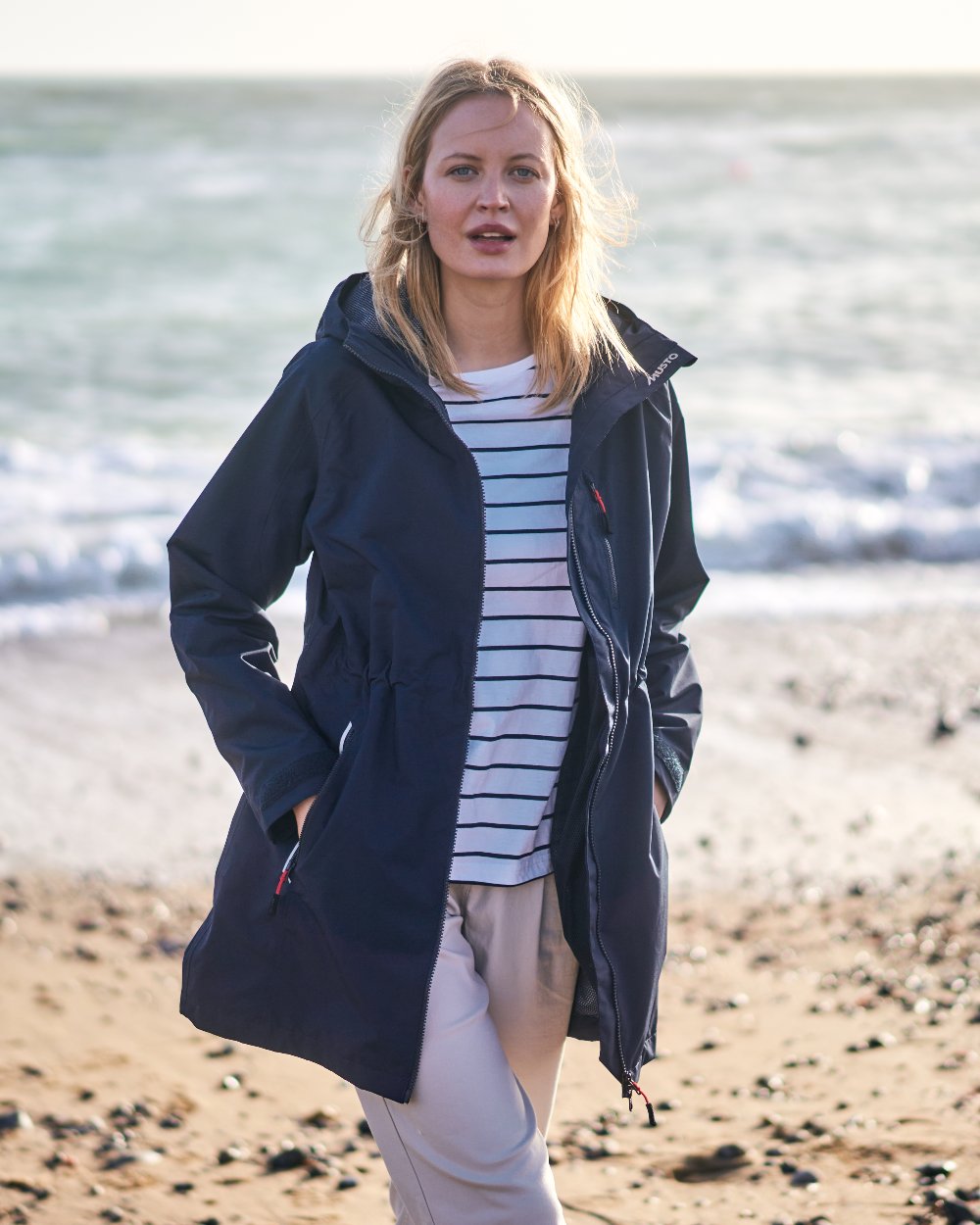 Navy coloured Musto Ladies Sardinia Rain Jacket on Beach background