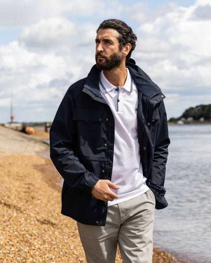 Navy Coloured Musto Mens Classic Shore Waterproof Jacket On A Beach Background 