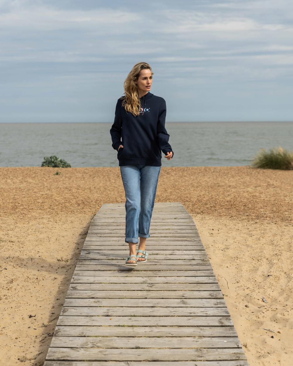 Navy Coloured Musto Womens 1964 Hoodie On A Beach Background