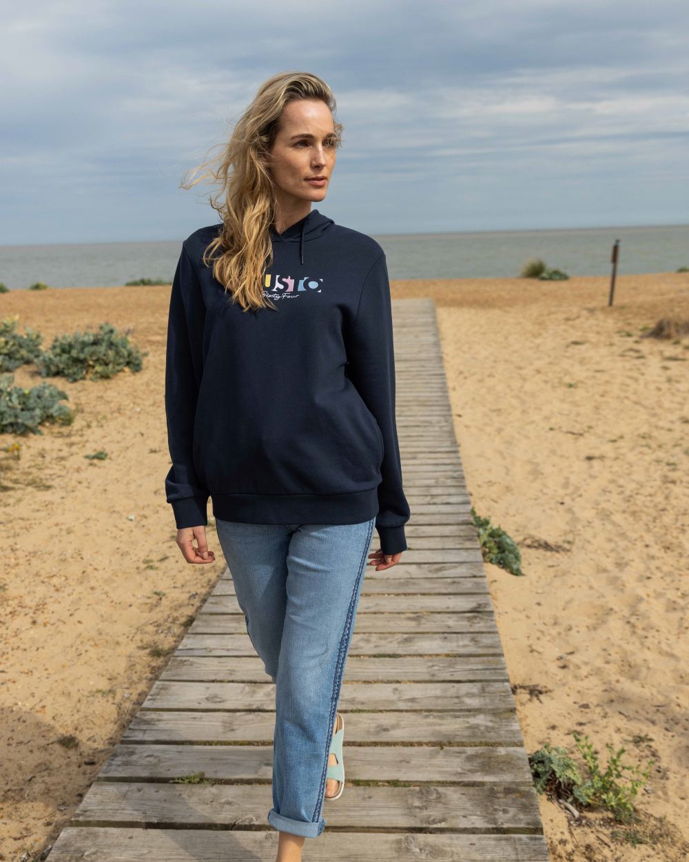 Navy Coloured Musto Womens 1964 Hoodie On A Beach Background
