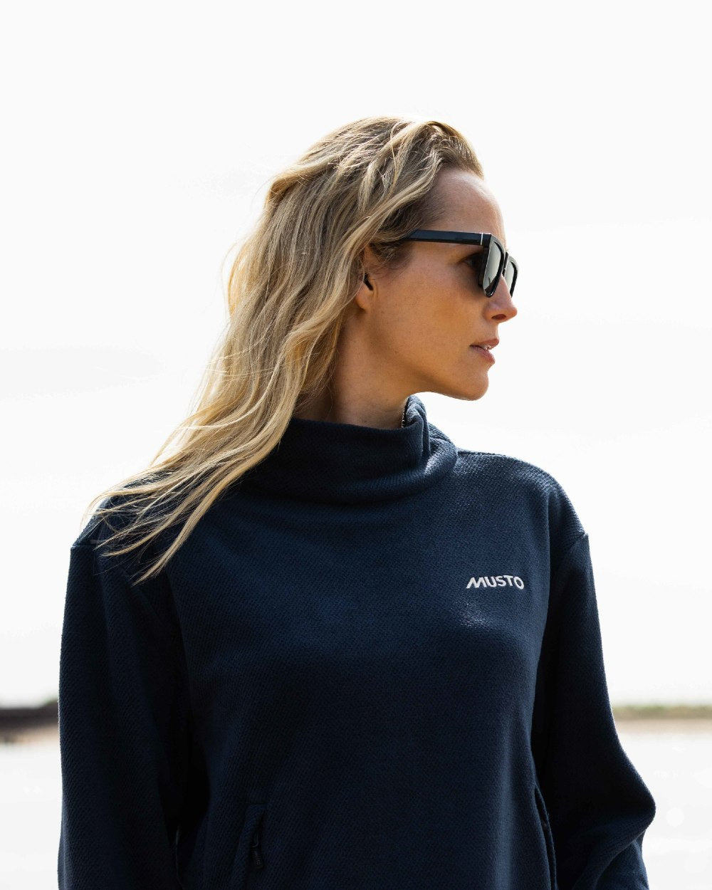 Navy Coloured Musto Womens Classic Fleece Pullover On A Beach Background
