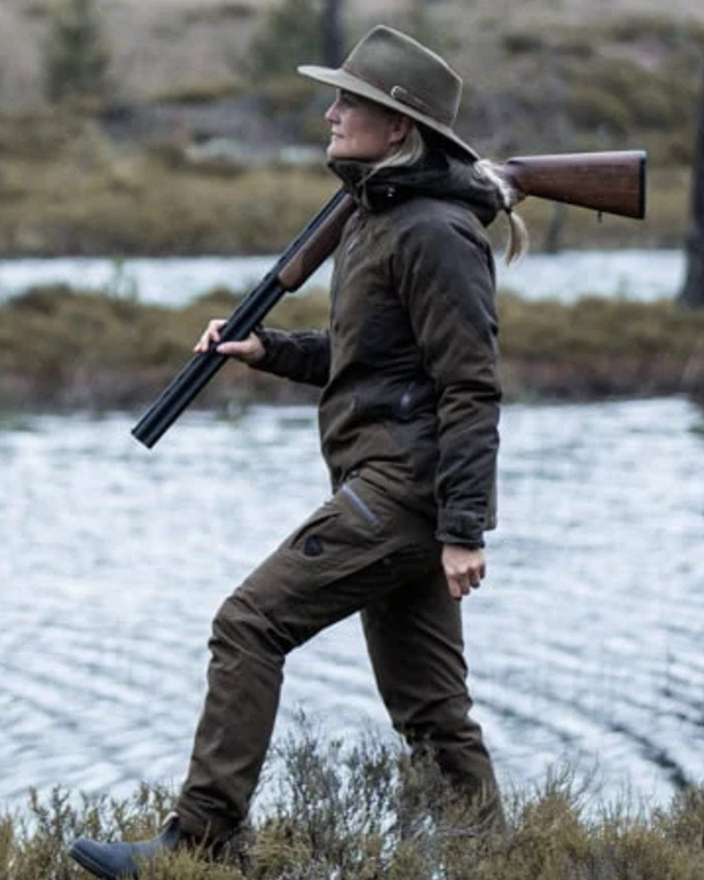 Green coloured Northern Hunting Womens Elk Ragna Waterproof Jacket on forest background