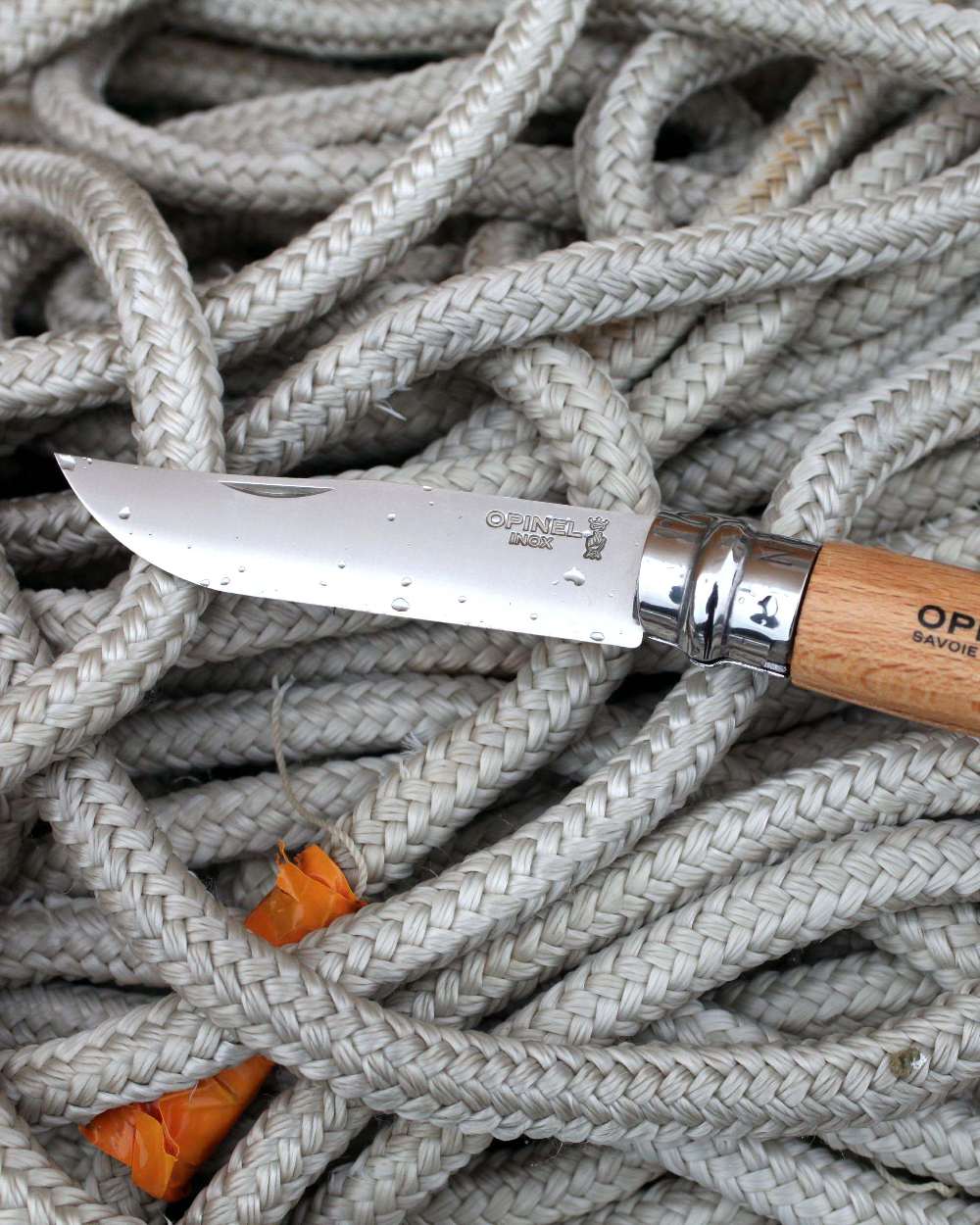 Stainless Steel coloured Opinel Classic Originals Knife on rope background