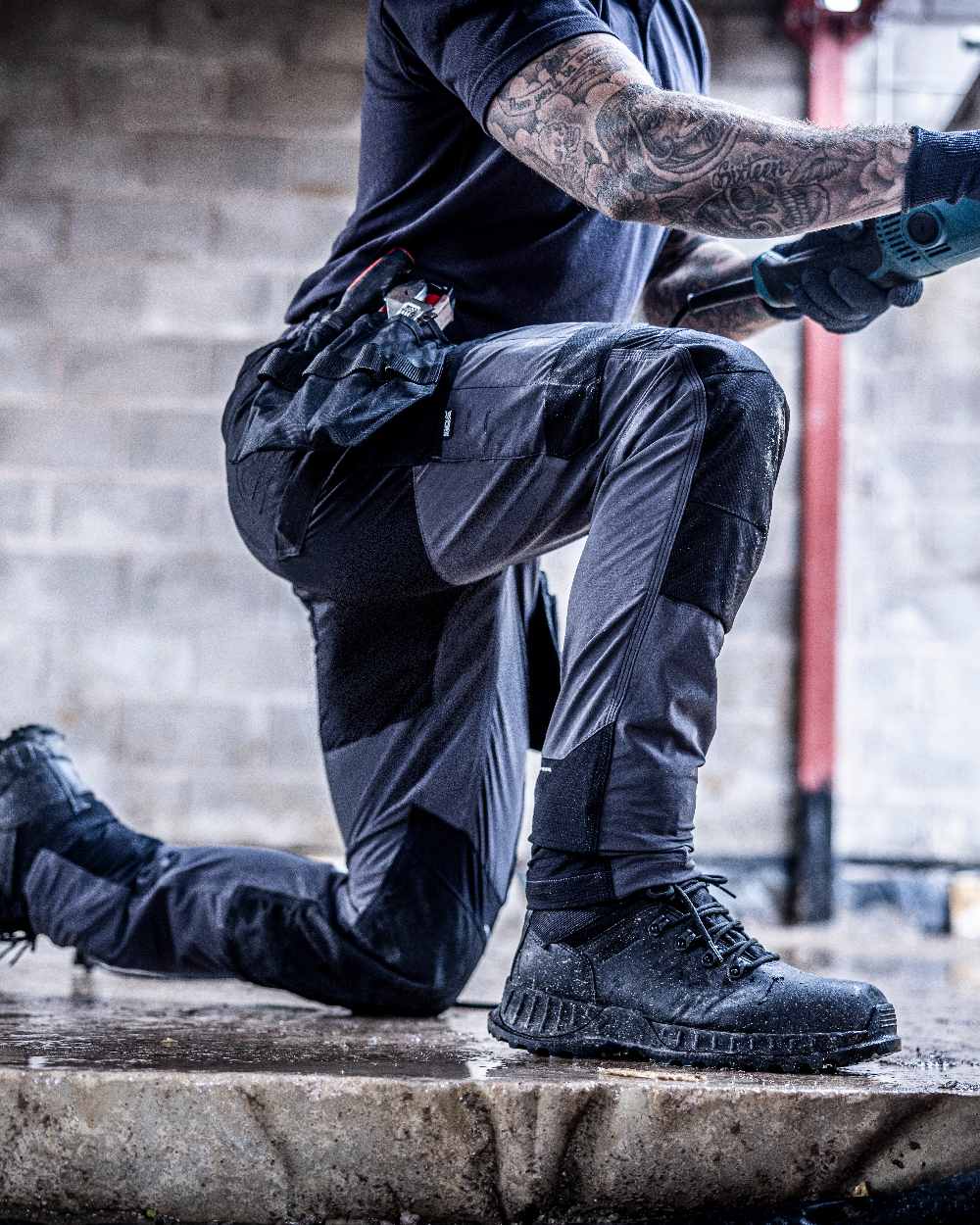 Slate Grey Black coloured Regatta Mens 4Tex Stretch Holster Trousers on wall background