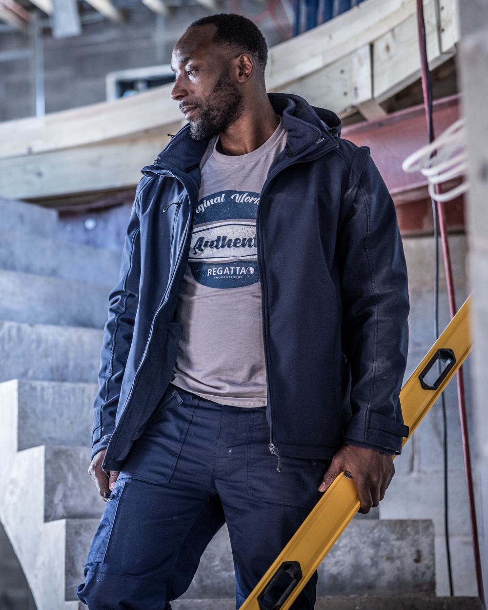 Navy coloured Regatta Professional Mens Erasmus 4 In 1 Softshell Jacket on construction background