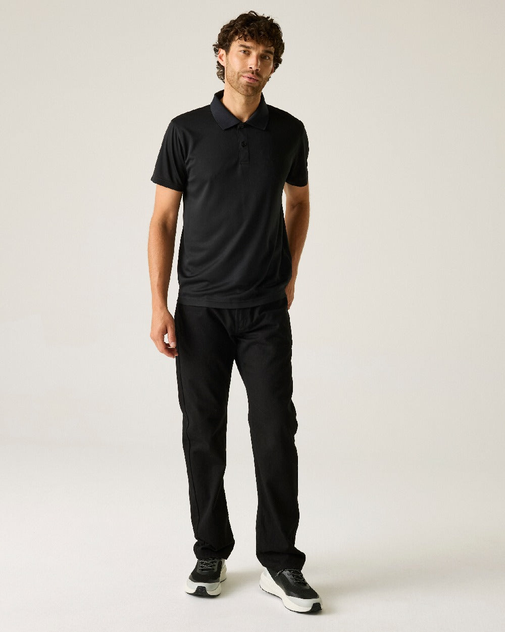Black colour Regatta Professional Mens Pro Wicking Pique Polo Shirt on beige background