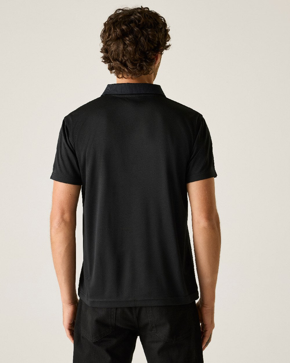 Black colour Regatta Professional Mens Pro Wicking Pique Polo Shirt on beige background
