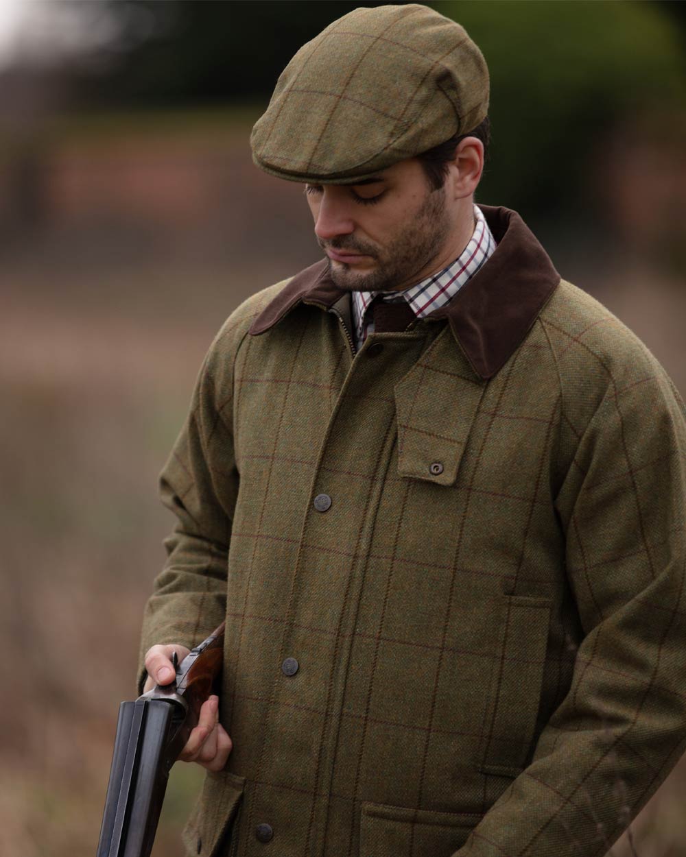 Lichen coloured Alan Paine Rutland Waterproof Tweed Shooting Coat on forest background