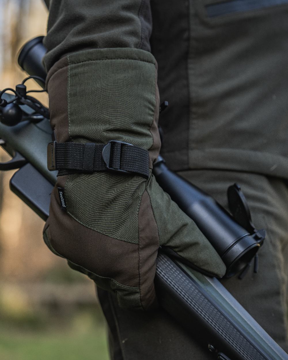 Pine Green coloured Seeland Celsius Heat Gloves on forest background