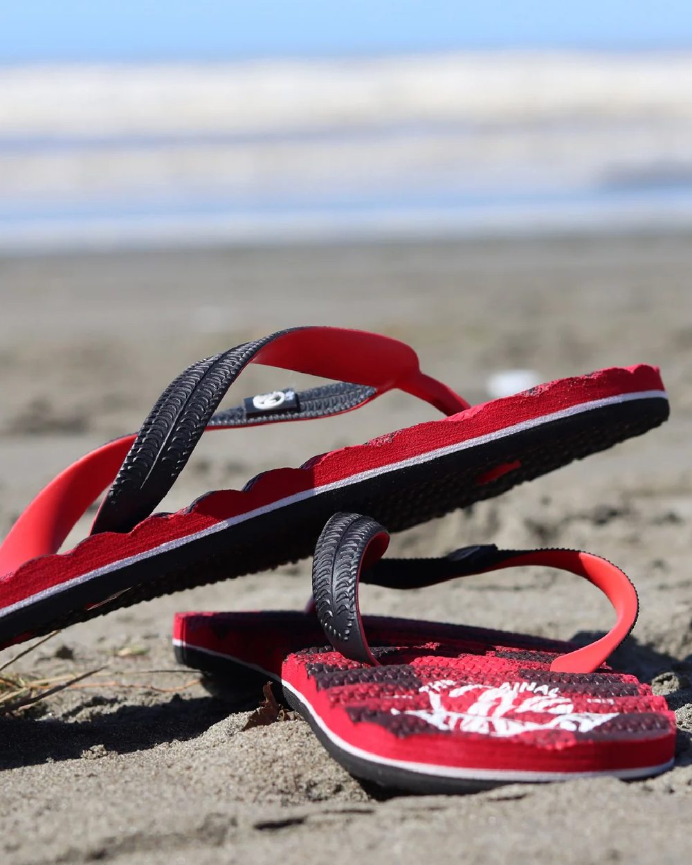 Red Black Check Coloured Swanndri Swanndal Jandal on beach background