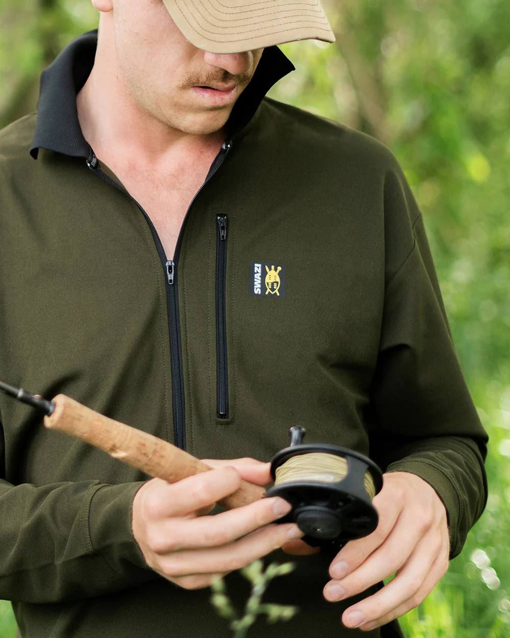 Olive coloured Swazi Mens Climb Max Long Sleeve Polo Shirt on leafy background