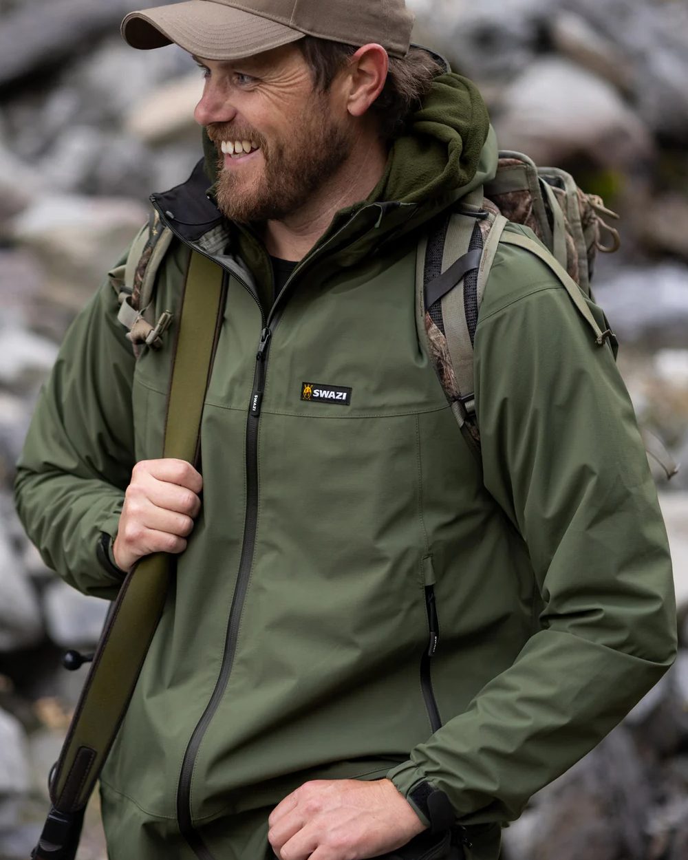 Olive coloured Swazi Mens Sentinel Ultralight Jacket on rock background