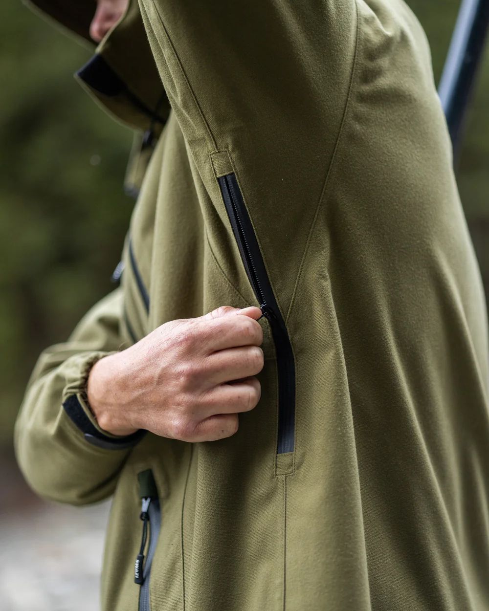 Tussock Green coloured Swazi The Ibex Jacket on blurry background
