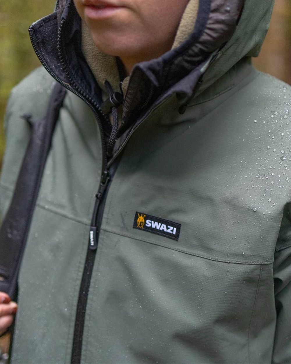 Olive oloured Swazi Womens Pioneer Ultralite Jacket on blurry background