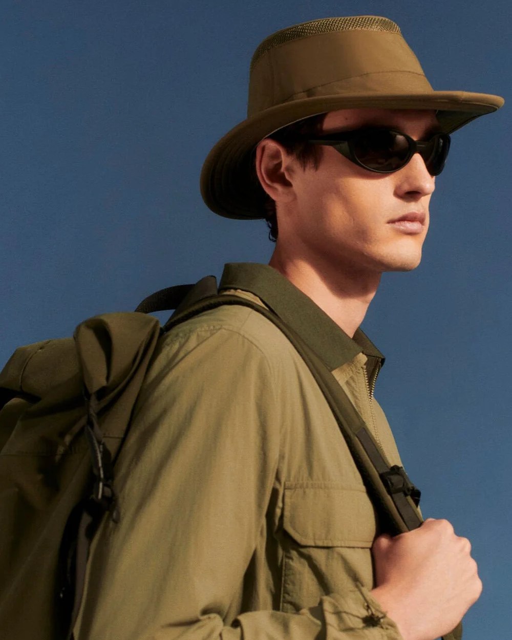 Olive coloured Tilley Airflo Medium Brim Recycled Hat on blue background