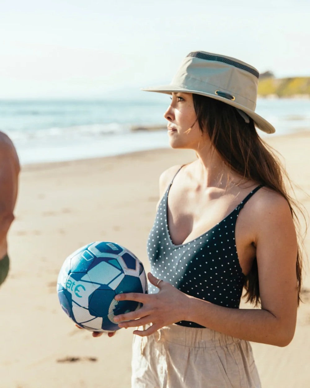 Rock Face coloured Tilley Airflo Medium Brim Recycled Hat on beach background
