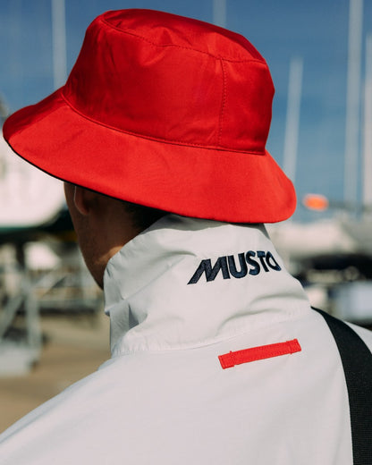 True Red/Navy Musto Salcombe Reversible Bucket Hat On A Boat Background 