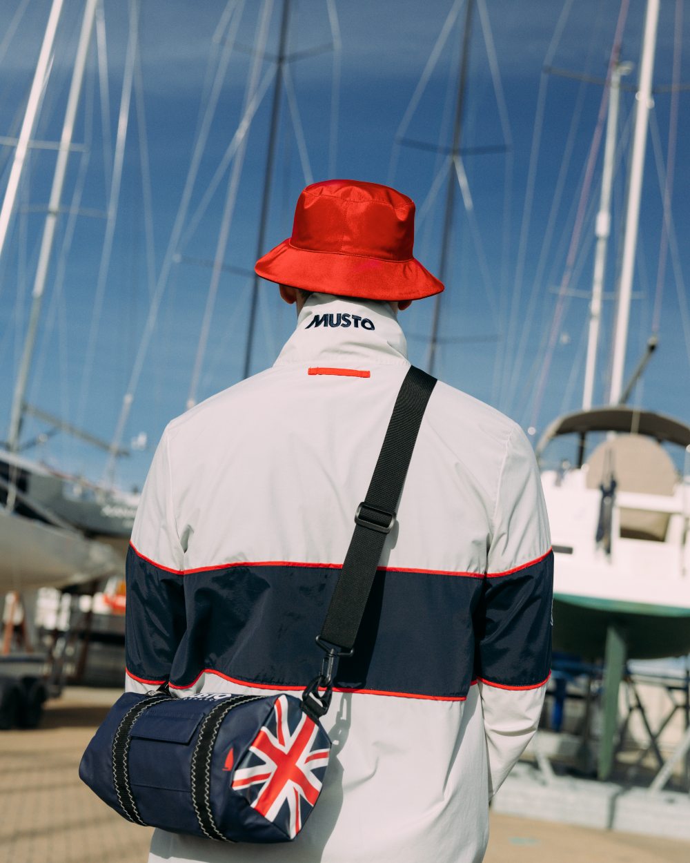 True Red/Navy Musto Salcombe Reversible Bucket Hat On A Boat Background
